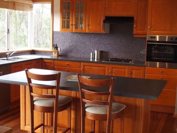 A kitchen with wooden cabinets, a tiled backsplash, and a built-in oven.