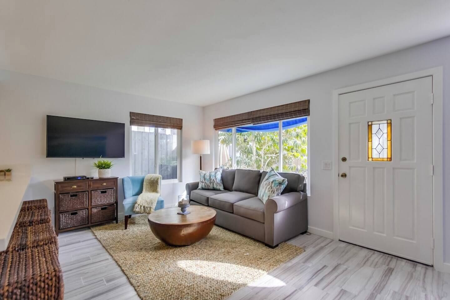 A living room with a sofa, coffee table, TV, and a door with a window.