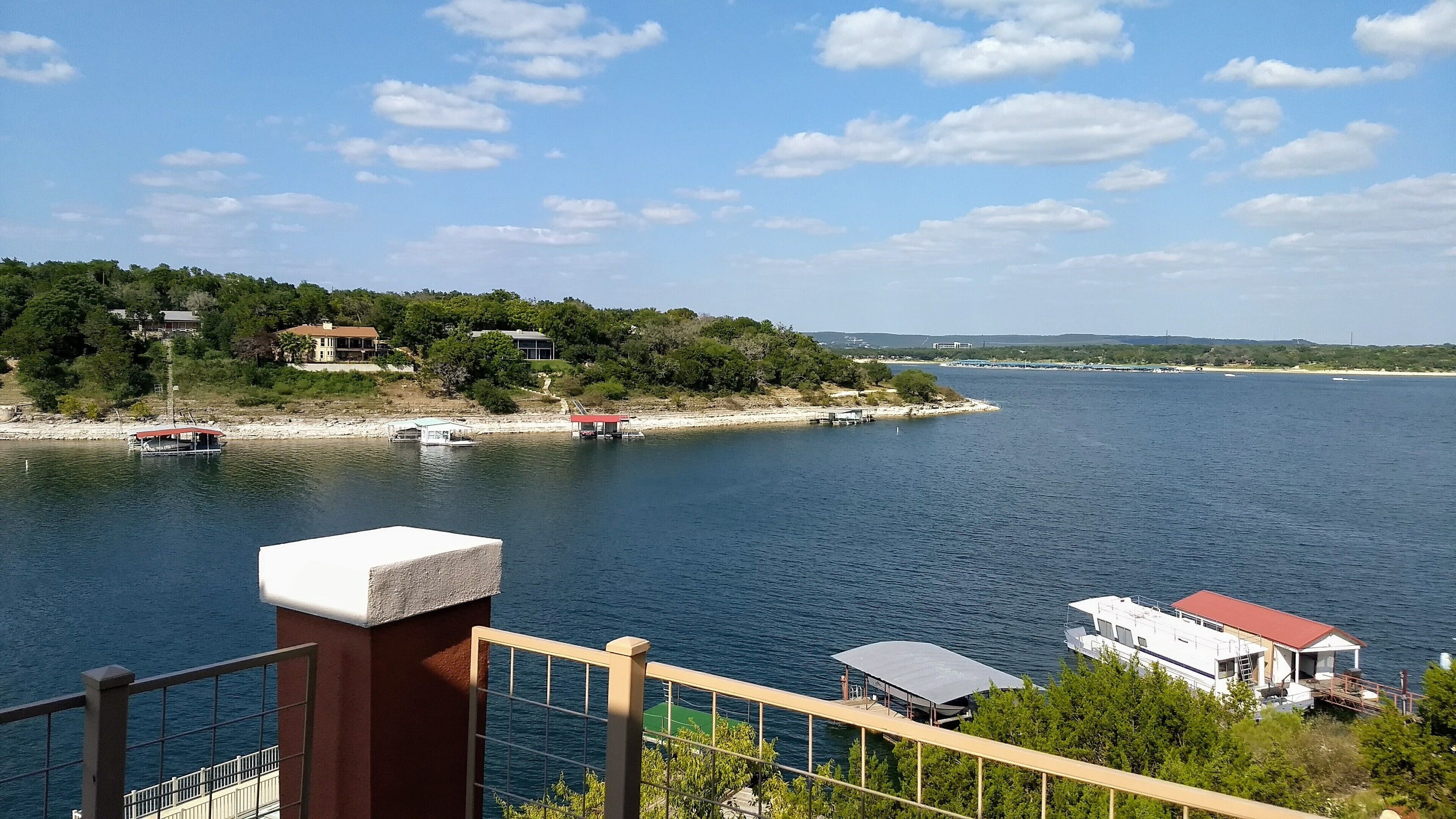 A waterfront property with a dock, boats, and a view of the surrounding landscape.