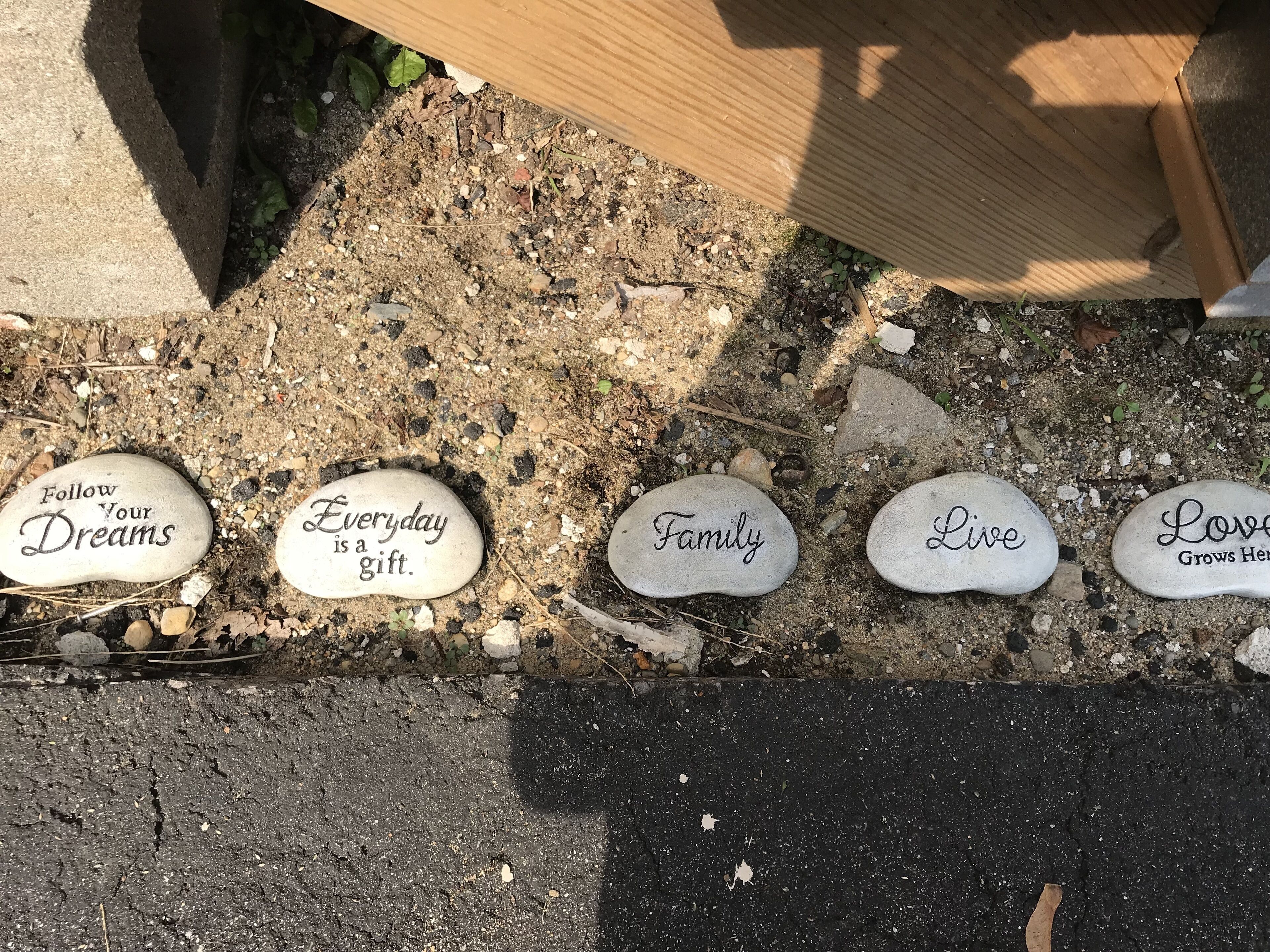 Una serie de piedras grabadas con mensajes inspiradores en un sendero de grava.