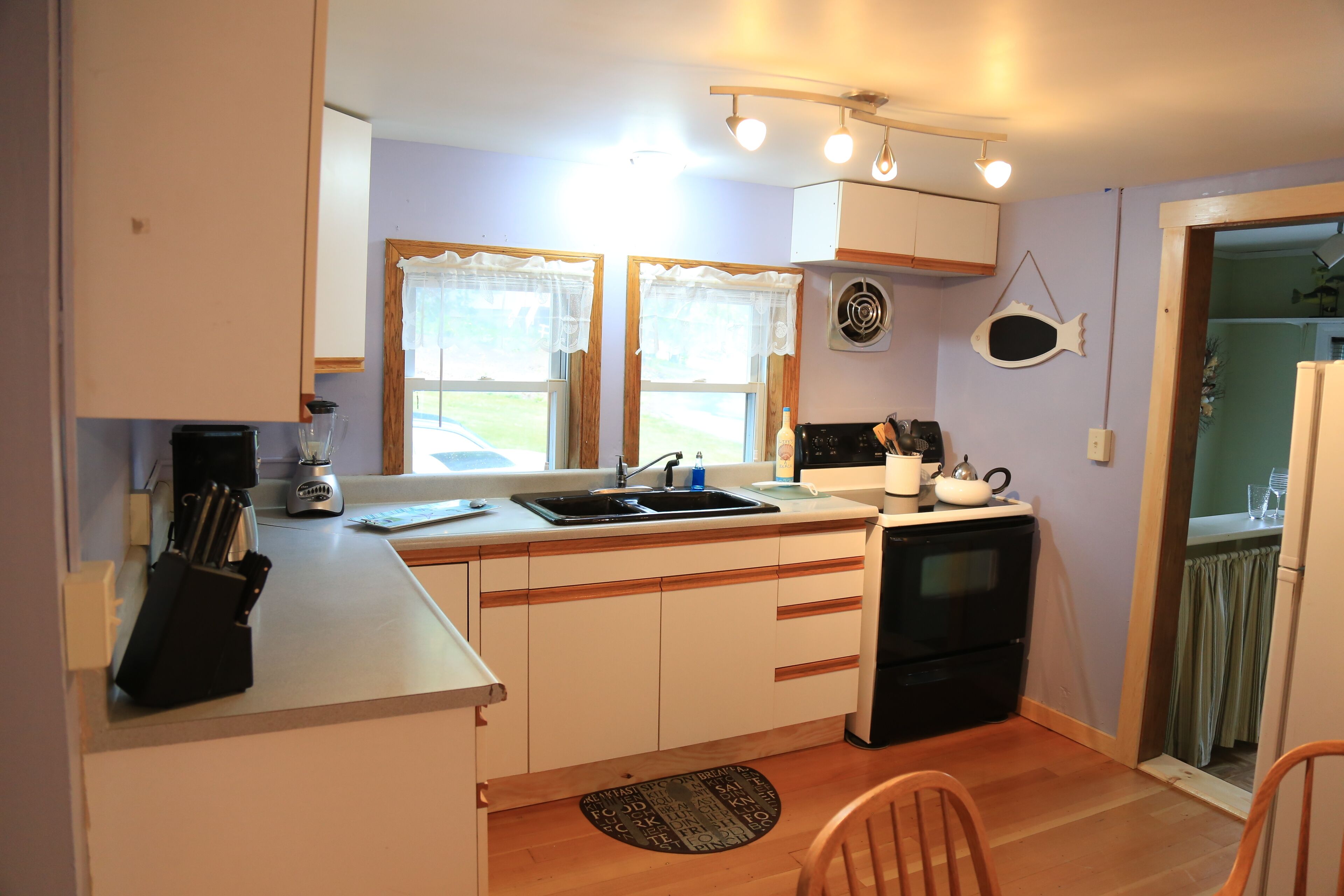Una cocina compacta con una isla central, un lavamanos y una estufa.