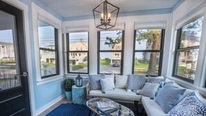 A sunroom with a sofa, a glass coffee table, and a potted plant. - Salty but Sweet - 3 min walk to Beach - Newly Renovated - Video! (Wells)