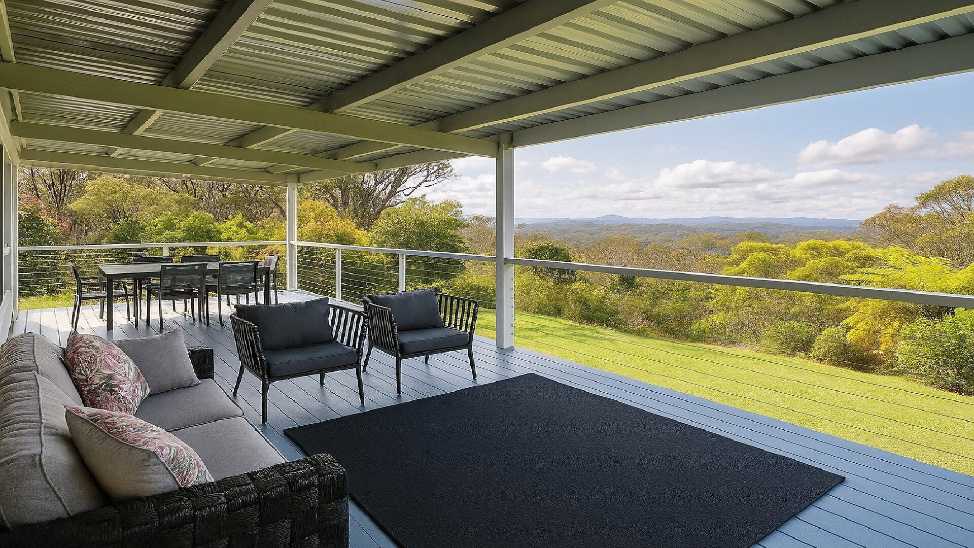 A covered outdoor seating area with a view of a green landscape.