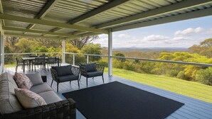 A covered outdoor seating area with a view of a green landscape. - Hat Hill Hideaway Amazing Valley Views (BLACKHEATH)