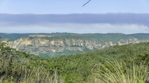 A natural landscape with a prominent rock formation and dense vegetation in the foreground. - Hat Hill Hideaway Amazing Valley Views (BLACKHEATH)