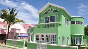 Un bâtiment à deux étages, doté d’une façade verte, de bordures blanches et de nombreuses fenêtres.