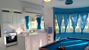 Une cuisine équipée d’une cuisinière intégrée, d’un évier et d’une table de billard.