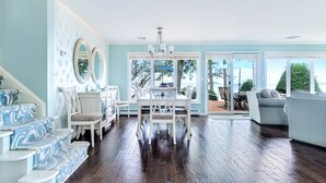 Un salón espacioso con comedor, ventanas amplias y vistas al exterior.