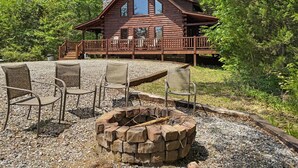 Eine Hütte mit Terrasse, Sitzgelegenheiten im Freien und einer Feuerstelle.