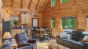 Ein Holzblockhaus-Interieur mit Essbereich, Küche und Sitzgruppe.