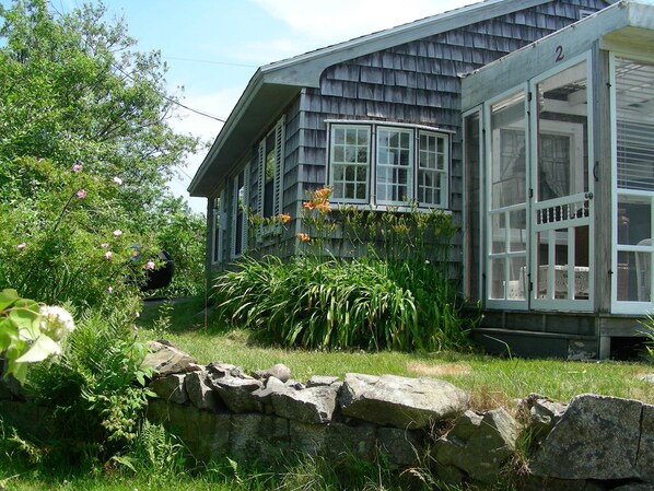 Lilies, iris, lupines, lilacs; antique windows and screened porch welcome you.