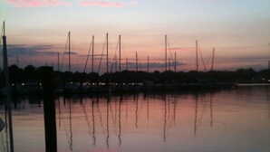 A marina at dusk with calm waters reflecting the sky.