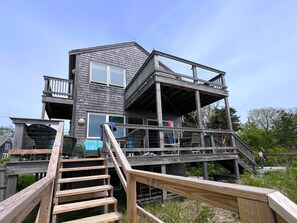 Ein mehrstöckiges Holzhaus mit einer Treppe, die zu einer oberen Etage führt.