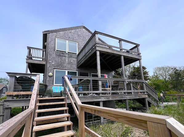 A multi-level wooden house with a staircase leading to the upper floor.