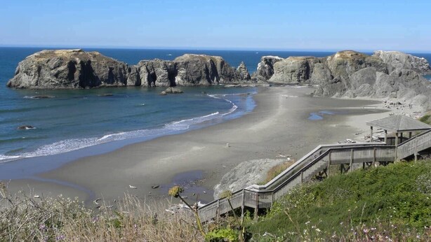 A coastal beach with rocky formations, a wooden walkway, and a clear view of the ocean. - All About the View North 3 bedroom oceanfront (Bandon)