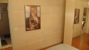 En hall med en affisch av Marilyn Monroe, ett ljust mattgolv och en tegelvägg.