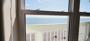 A view from a window overlooking a parking lot and the sea. - Oceanfront Condo-180 Gulf Views (Galveston)