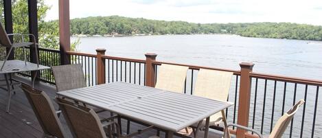 Una terraza con mesa y sillas que da a un lago.
