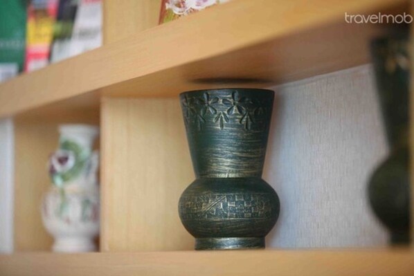 Une étagère avec un vase de couleur sombre et un objet décoratif.