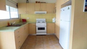 A compact kitchen with a stove, sink, and refrigerator. - Beach Cottage on Bali _ With WIFI (Blacksmiths)