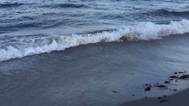 Ein Strand mit ankommenden Wellen.