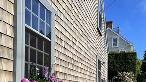 A wooden house with a brick pathway and flower boxes on the windowsills. - Charming Nantucket home. (Nantucket)