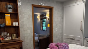 A kitchen with marble countertops, a wooden cabinet, and a vase of flowers. - Charming Nantucket home. (Nantucket)
