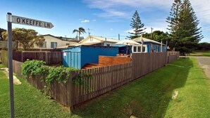 A residential property with a fenced backyard, a blue shed, and a house with a sloped roof. - Two Bedroom House Wooli (Wooli)
