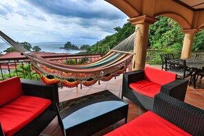 A hammock, wicker furniture, and a view of the sea. - Luxurious Family-Friendly, 3BR Condo With Pool Less Than 5 Min Walk To The Beach (Puntarenas)