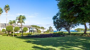 A resort with multiple buildings, manicured lawns, and a large tree in the foreground.