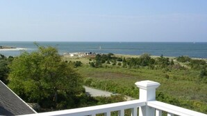 A coastal view with a clear sky, a beach, and a white railing. - Expansive Home With Gorgeous Bay Views! (1052) (Brewster)