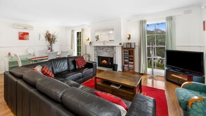 A modern living room with a fireplace, a television, and a dining area.