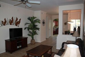 Relax in this inviting living room with a sofa, TV, and potted plant.