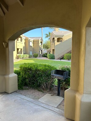 Enjoy a tranquil courtyard with a barbecue grill, beautifully manicured lawn, and Mediterranean-style architecture.