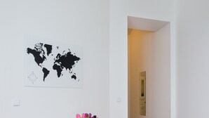 Et spiseområde med et hvidt bord, orange stole, et verdenskort på væggen og en hængende lampe.