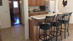 Una cocina moderna con armarios de madera, una isla integrada con taburetes altos y un refrigerador.