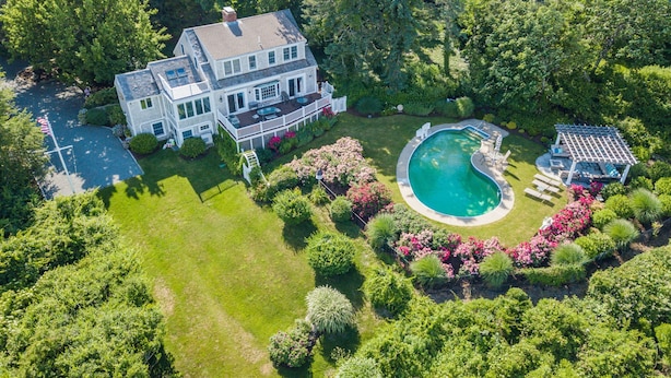 A large house with a swimming pool and a patio area. -  Luxury Waterfront Home with Pool and Dock  NEW 5% Discount Until Feb. 28th (eastham)