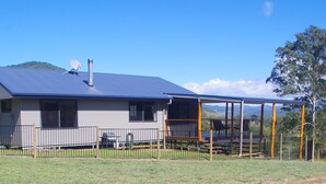 A single-story house with a covered porch and a satellite dish.
