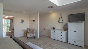 A bedroom with a bed, a chair, a small table, a TV, and a cabinet. - Relaxing Townhome by Lemon Bay, minutes to Beach (Englewood)