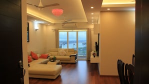 A modern living room with a sofa, a coffee table, and a dining area with chairs.