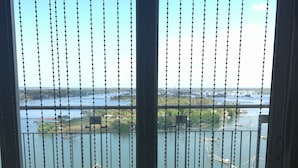 A balcony with a view of a river and distant buildings.