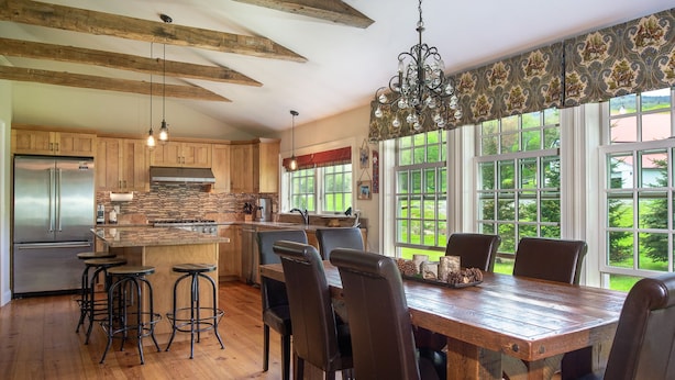 A spacious kitchen with wooden beams, a stainless steel refrigerator, and a large island with stools. - Private Family Estate for any Season - Hermitage Club/Inn (West Dover)