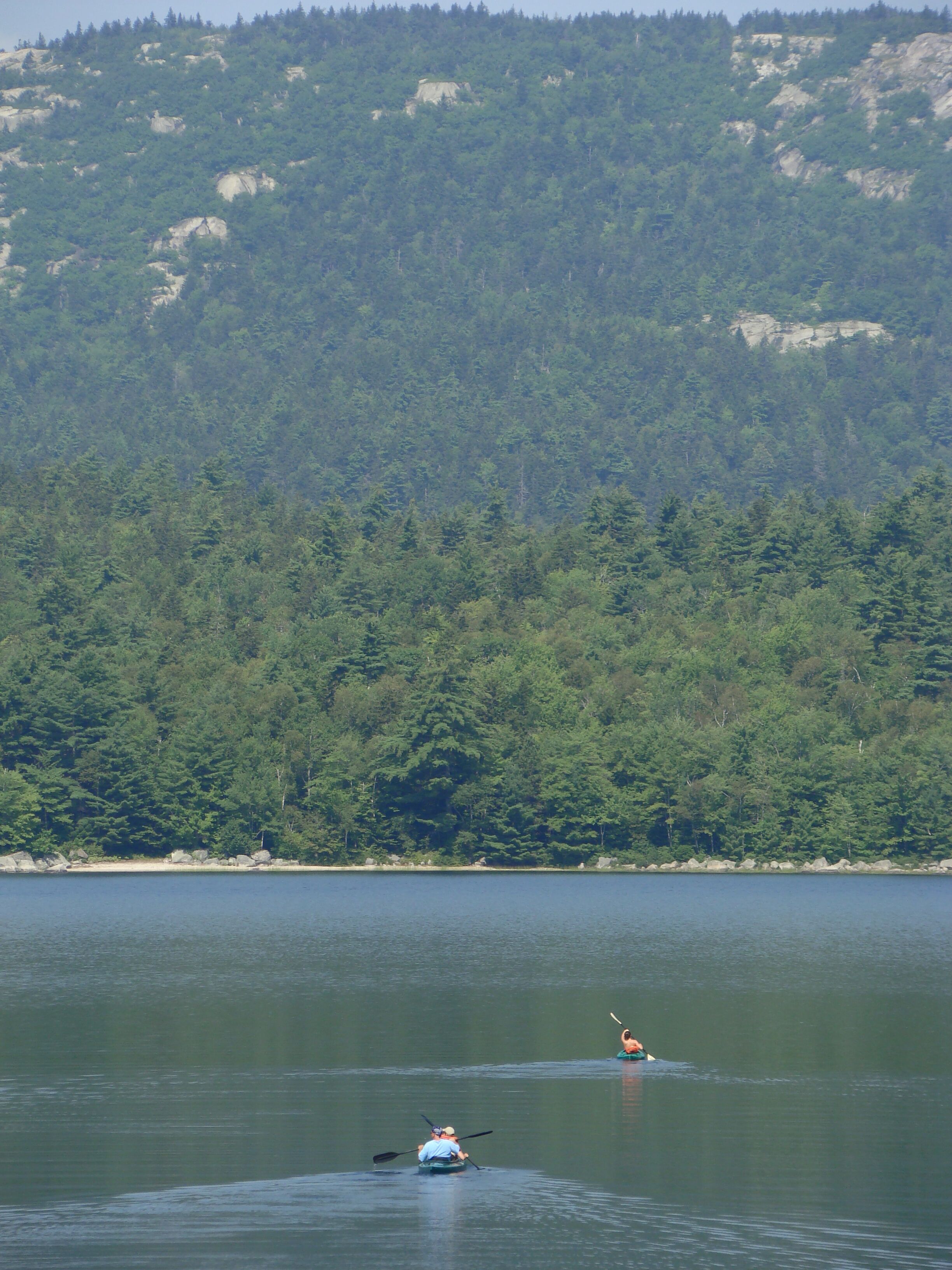 Un lac paisible où l’on peut faire du kayak, et où une personne est en train de pagayer.
