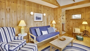 Une pièce chaleureuse avec un canapé bleu, un fauteuil à rayures et une table basse en bois.