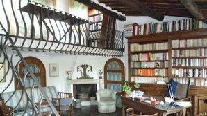 A library with bookshelves, a fireplace, and a staircase. - luxury penthouse in the heart of Rome with two terrific terraces on the domes (rome)