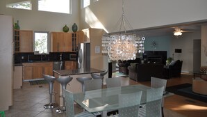 Una cocina amplia con electrodomésticos modernos, un comedor con mesa de vidrio y una sala de estar con chimenea.
