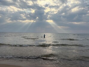 A beach with waves and a person standing in the water. - Beautiful Lake Michigan Beachfront Luxury Home. Private Beach, Pool + Hot Tub (Coloma)