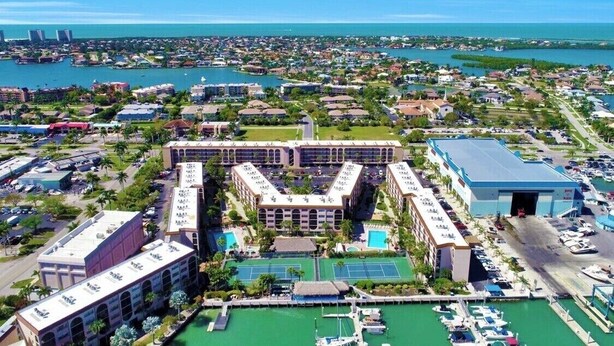 A resort with multiple buildings, a marina, and a large pool area. - Great Unit On Marco River (marco island)
