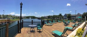 A wooden deck with outdoor seating and a view of a body of water. - Cute and Cozy Venetian Bay Townhome - VB007 (Kissimmee)