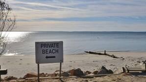 Un panneau indiquant une plage privée, avec une flèche pointant vers la gauche.